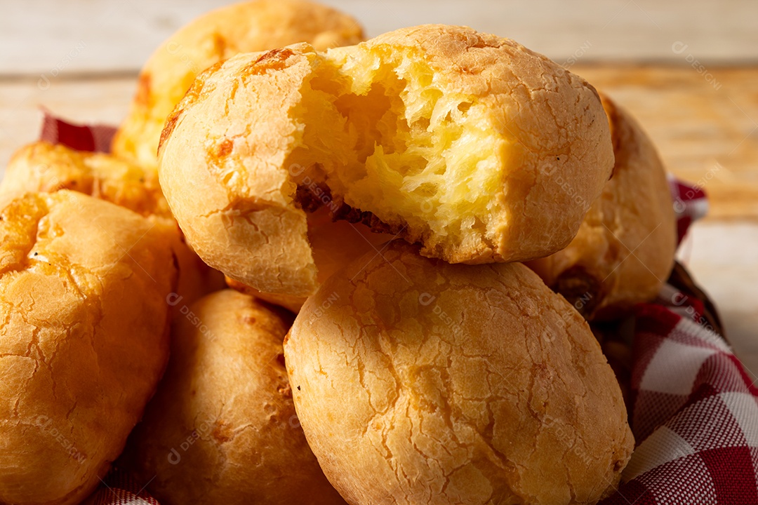 Pão de queijo em mesa de madeira com café preto