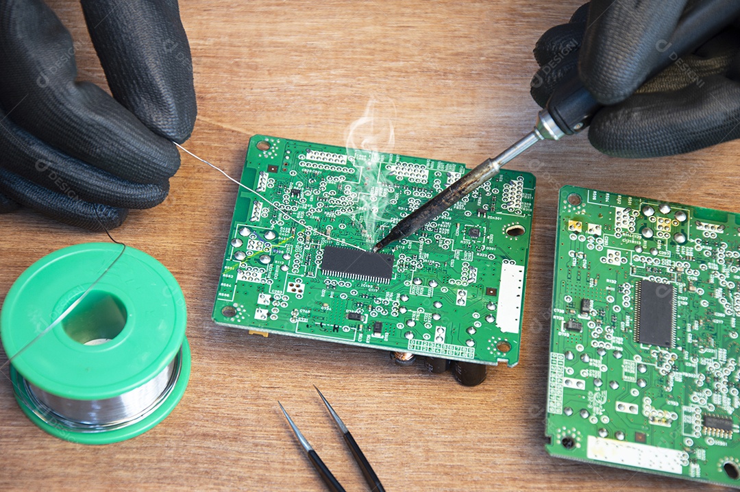 Técnico soldando peças de uma placa mãe