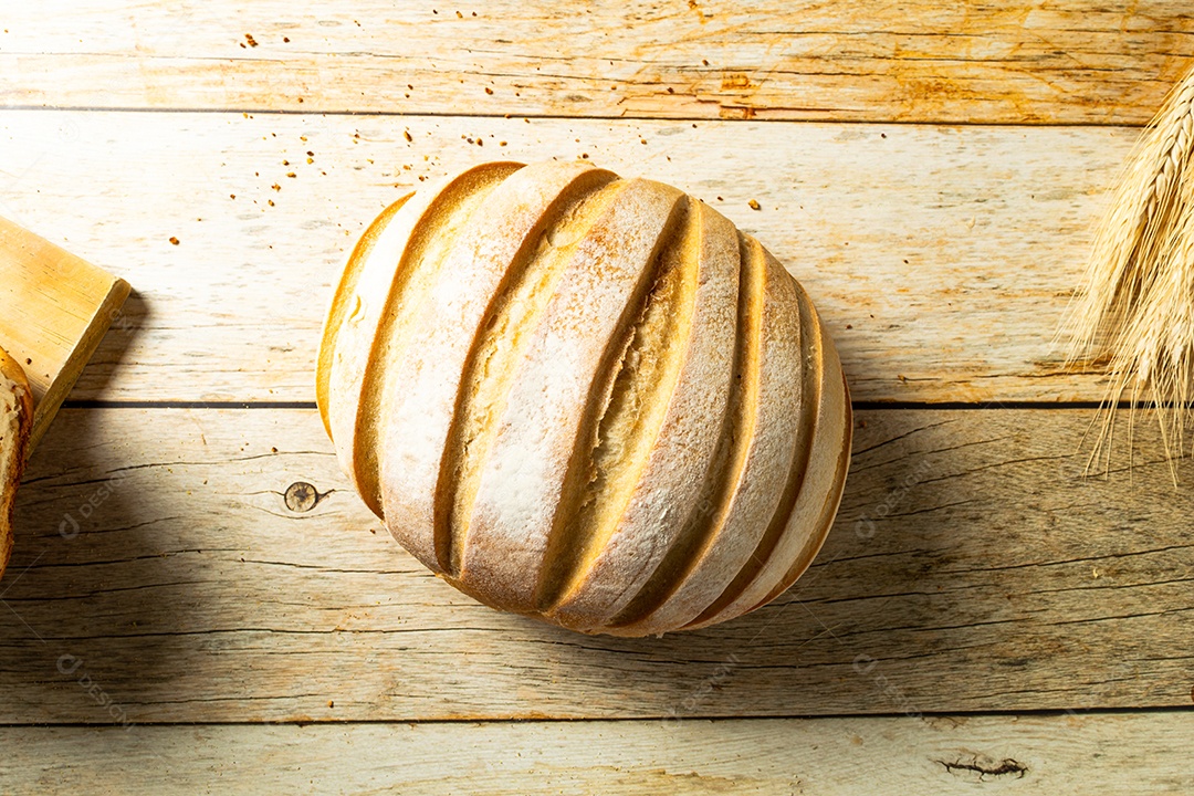 Vista superior de pão redondo sobre a mesa de madeira.