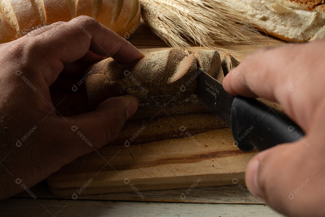 homem cortando fatias de pão escuro ou pão australiano.