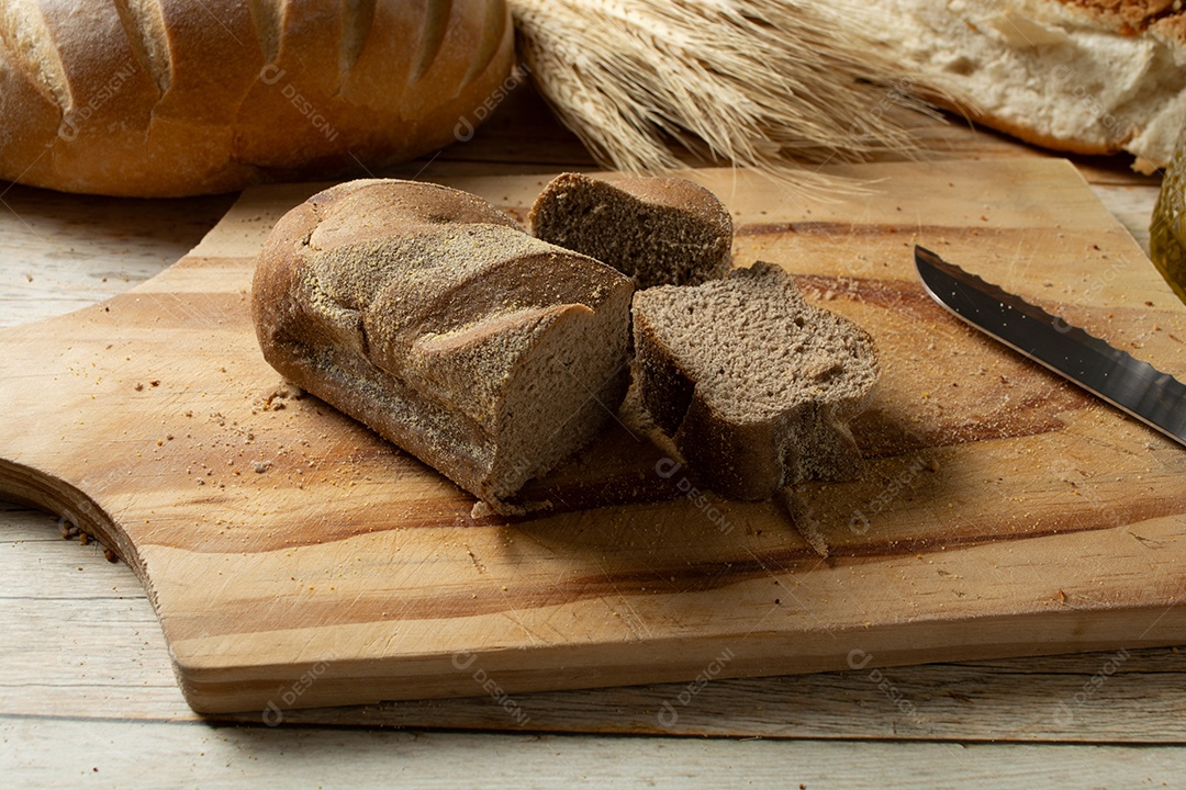 Homem cortando fatias de pão escuro ou pão australiano.