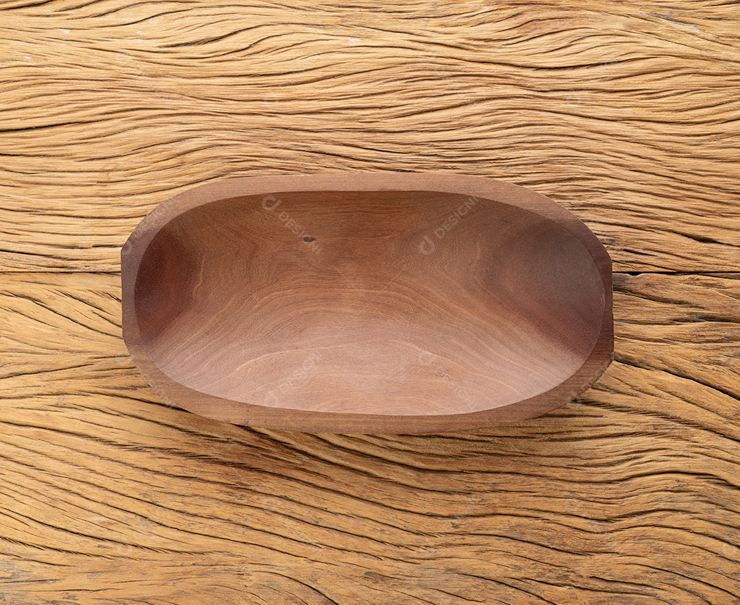 Tigela de madeira artesanal vazia sobre a mesa de madeira.