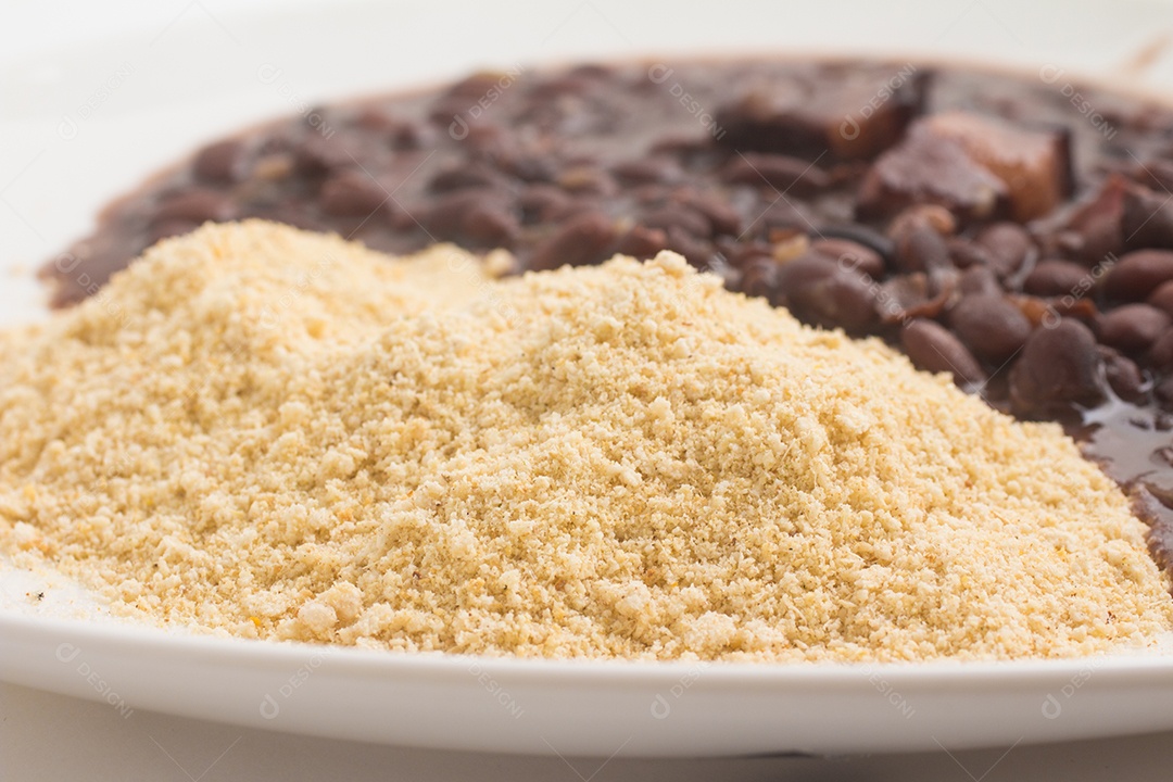 Farofa de mandioca com feijão preto cozido em fundo branco
