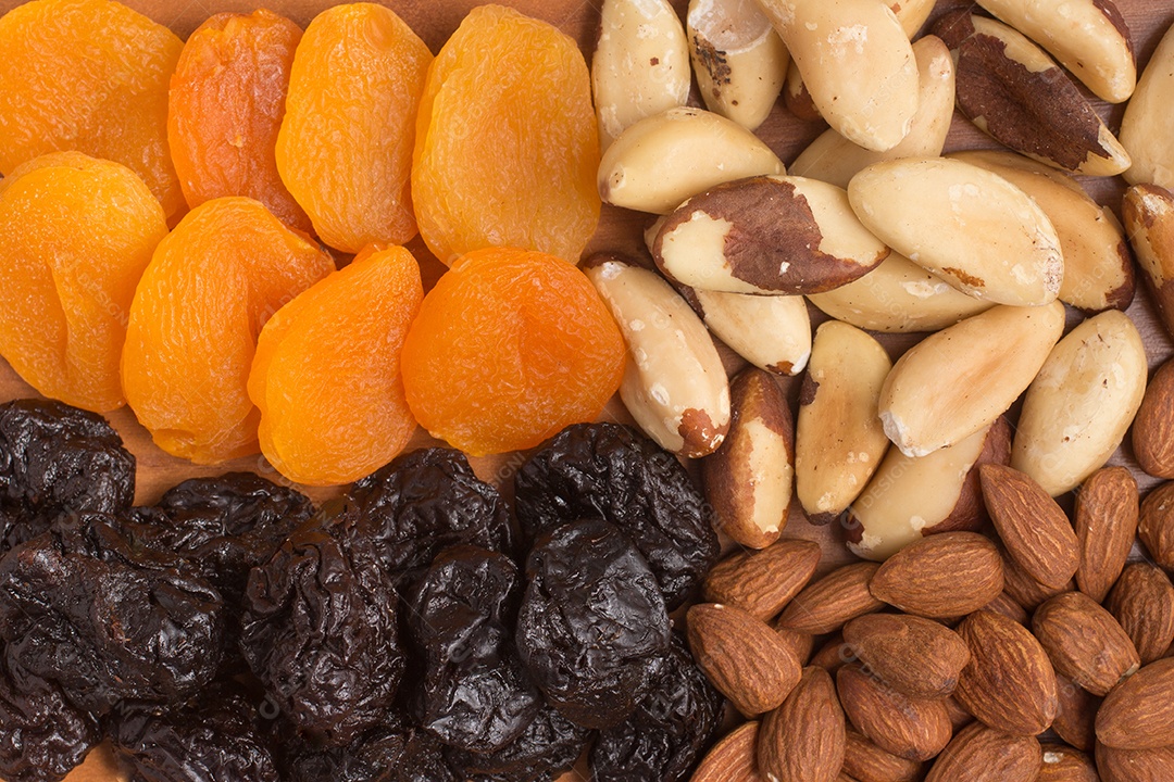 Punes, Ameixas, Castanha do Pará e Amêndoas sobre mesa de madeira