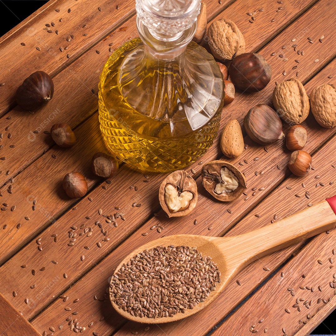 Gordura Saudável. Nozes, azeite e linhaça sobre uma mesa de madeira.
