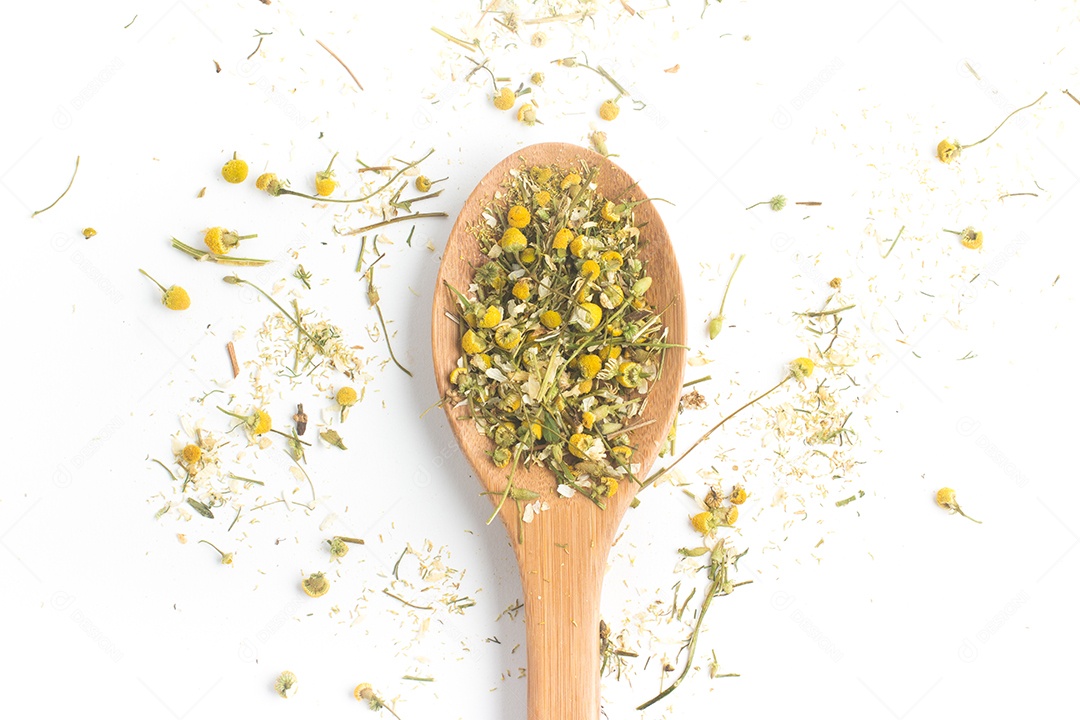 Chá de camomila seco em uma colher isolada em fundo branco