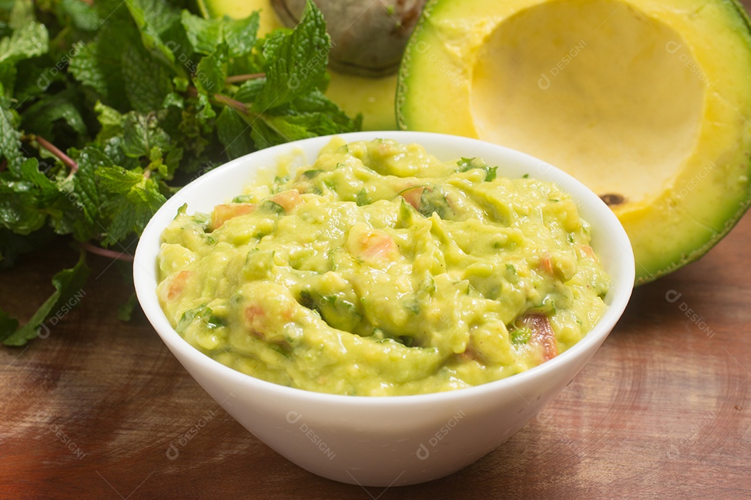 Guacamole em uma tigela sobre uma mesa de madeira
