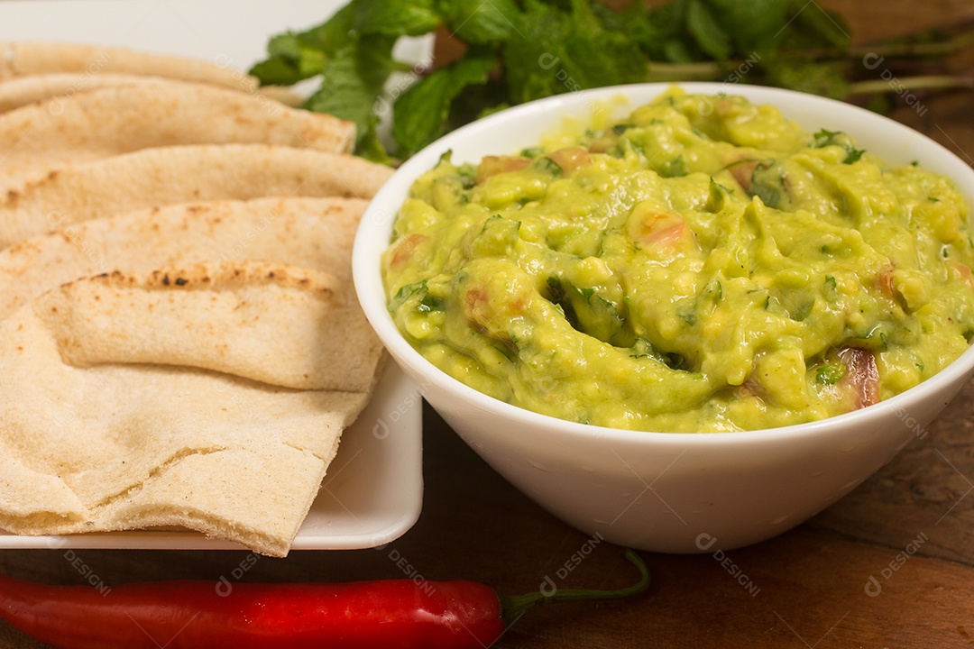Guacamole em uma tigela sobre uma mesa de madeira
