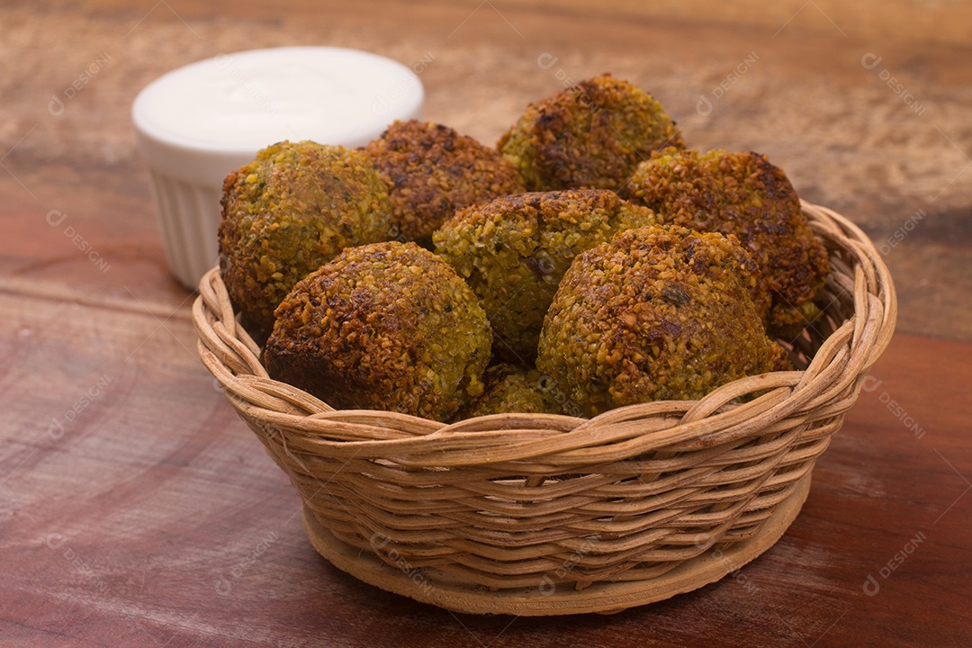 Bolas de falafel em uma cesta sobre uma mesa de madeira