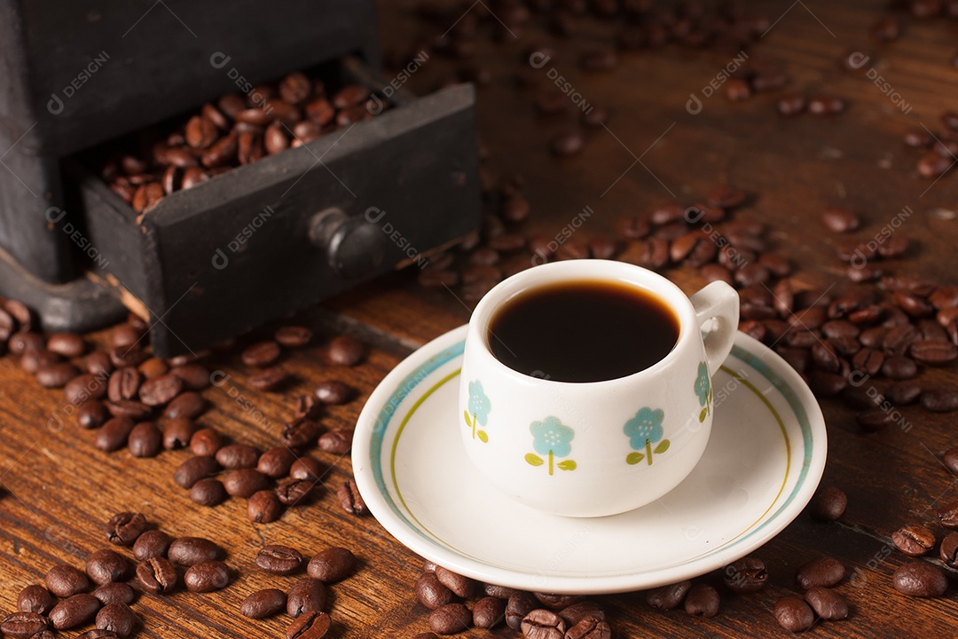 Moedor de café antigo, grãos de café e xícara