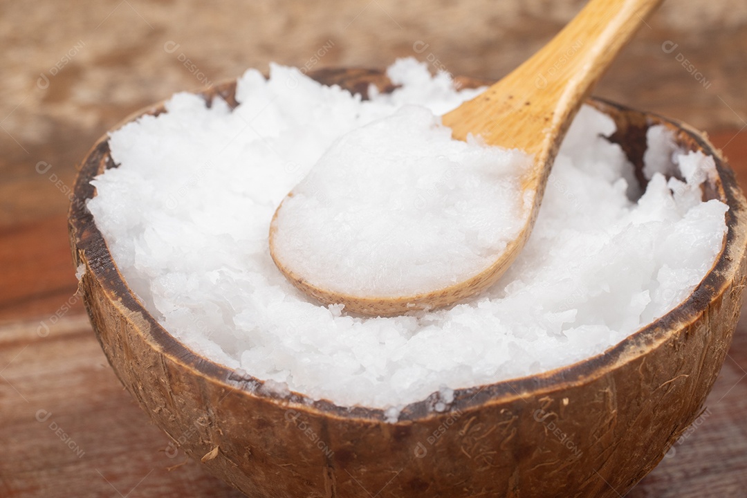 Óleo de coco na tigela de coco em fundo branco