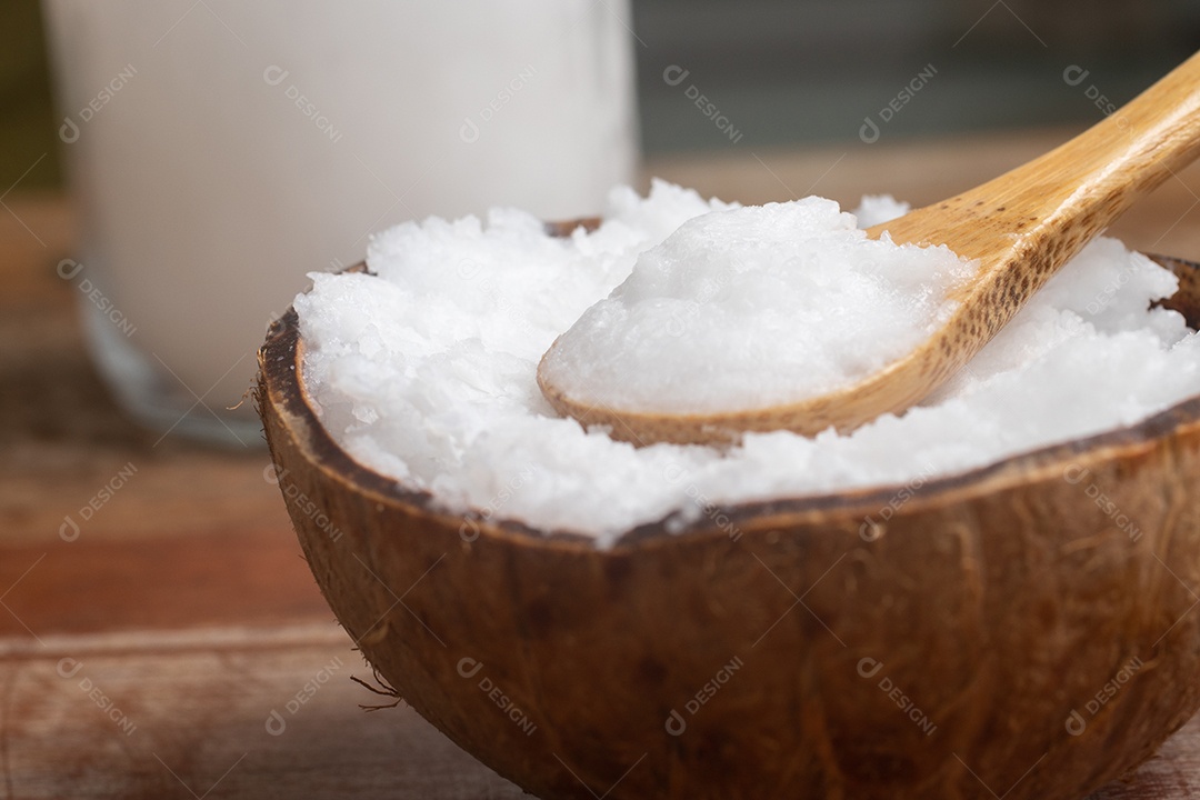 Óleo de coco na tigela de coco em fundo branco