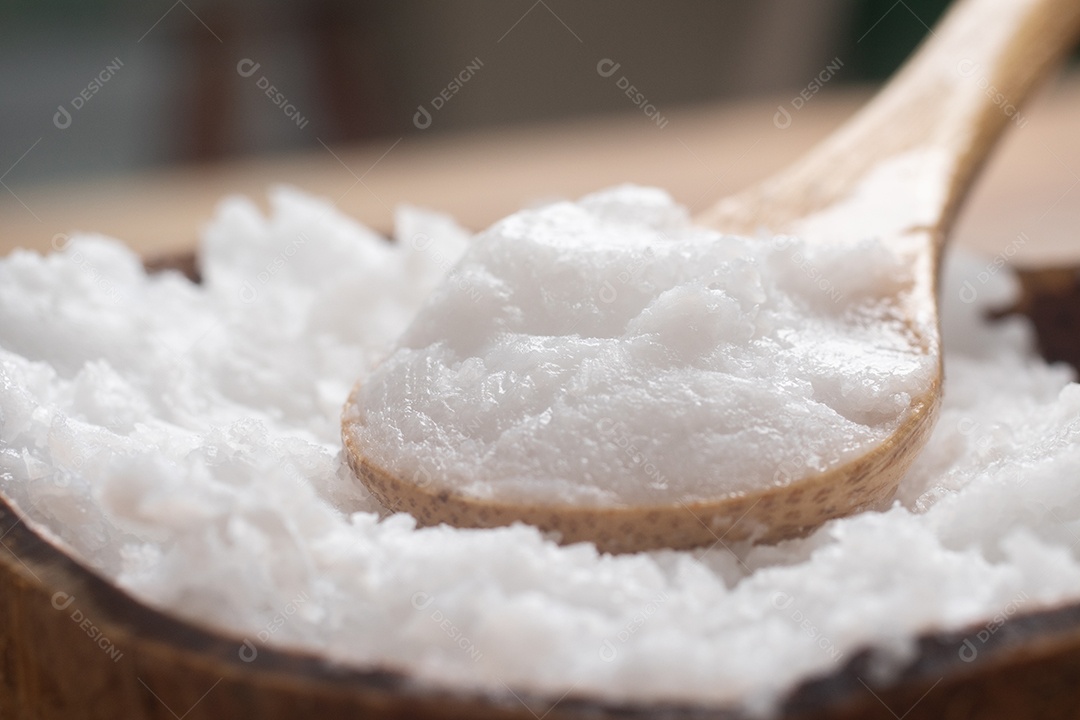 Óleo de coco na tigela de coco em fundo branco