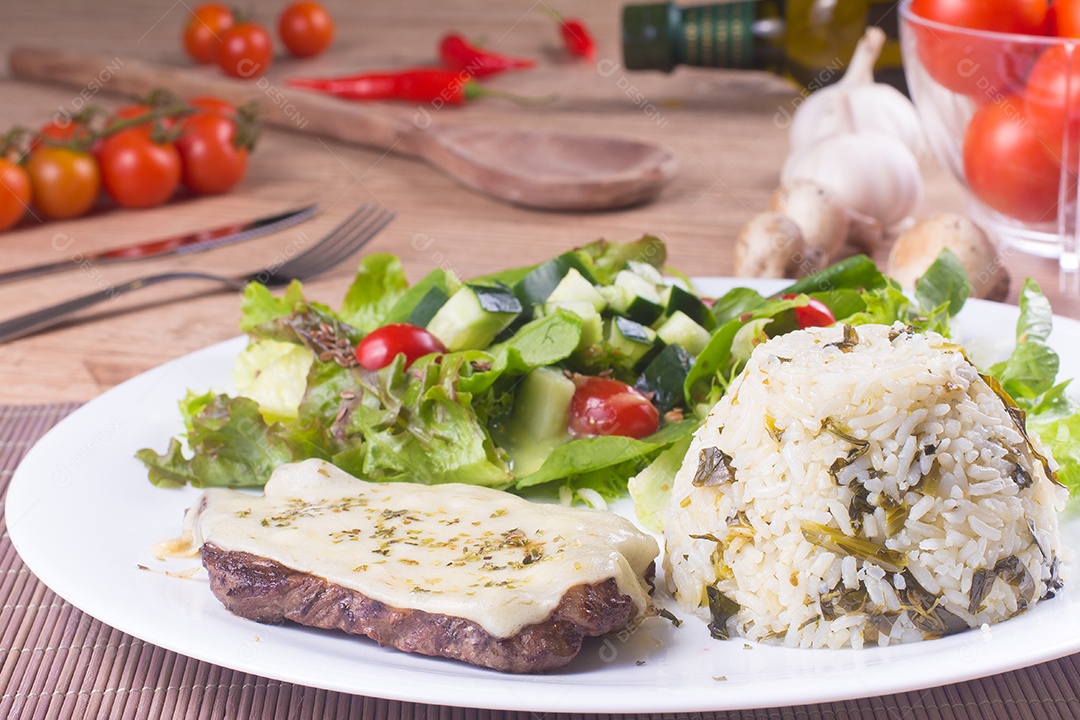 Filé Mignon, arroz e salada fresca e saudável sobre uma mesa de madeira