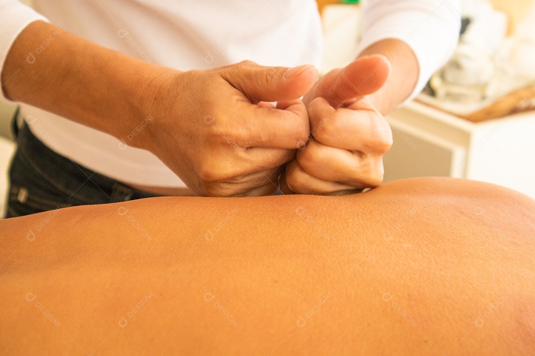 Mulher idosa relaxando na mesa de massagem recebendo massagem.