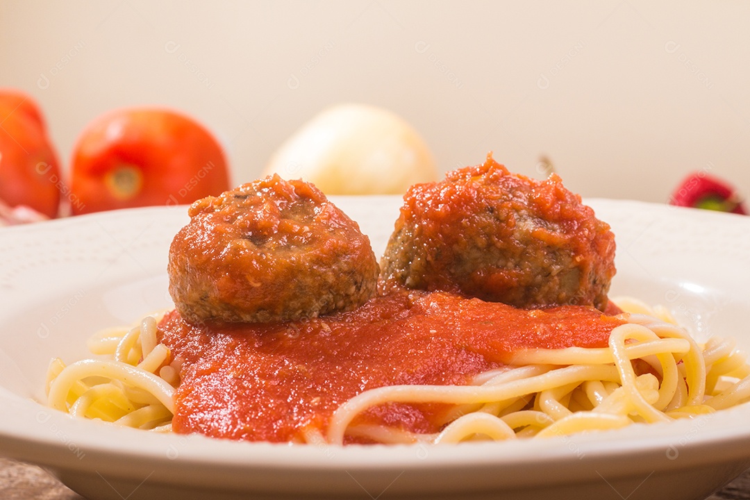 Espaguete com almôndega e molho de tomate sobre uma mesa de madeira