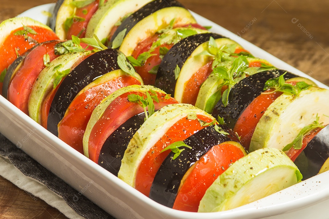 Ratatoullie. Berinjela, Tomate e Abobrinha. Comida crua sobre uma mesa de madeira