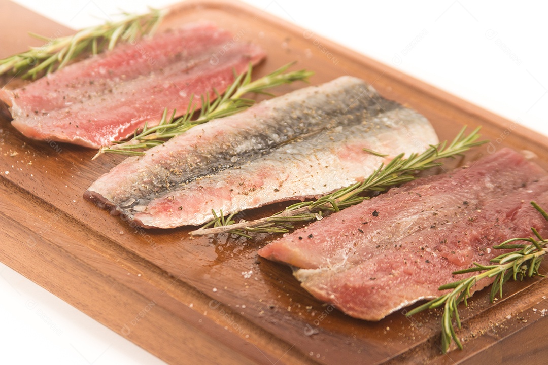 Filé de sardinha fresca crua sobre uma tábua de madeira