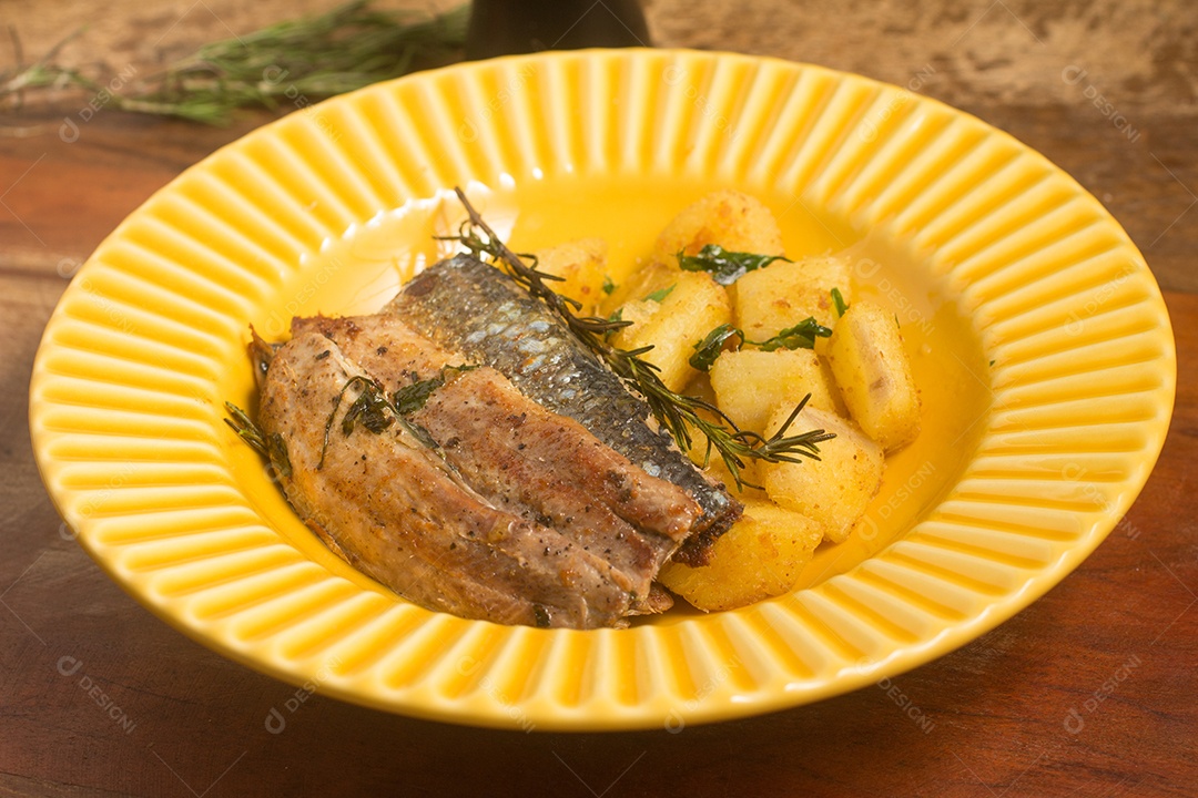 Filé de Sardinha com Aipim sobre mesa de madeira