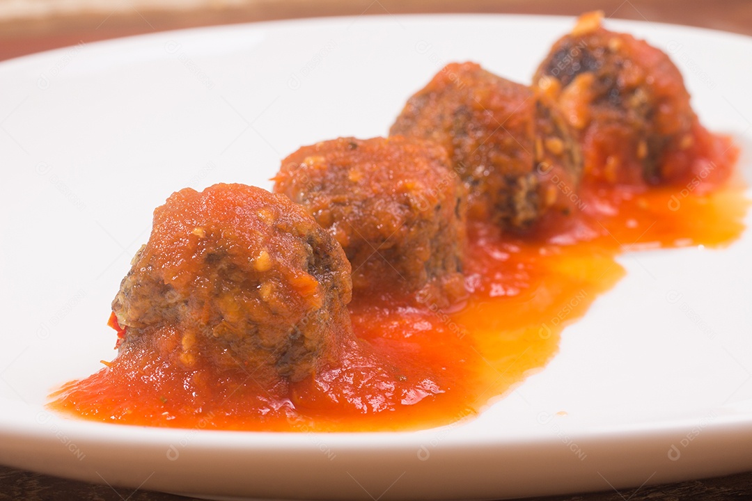 Almôndega e molho de tomate sobre uma mesa de madeira