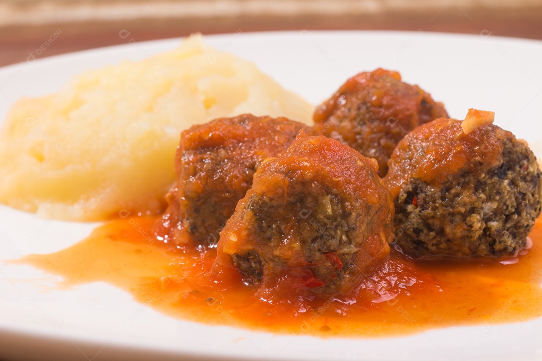 Almôndega e molho de tomate sobre uma mesa de madeira