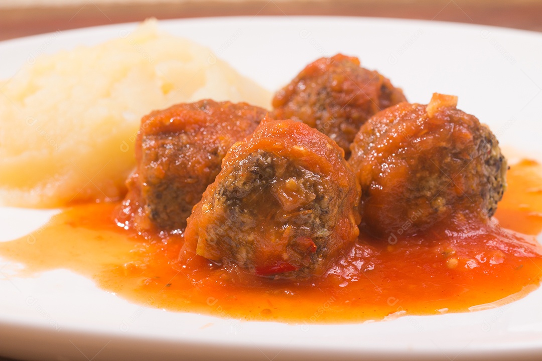 Almôndega e molho de tomate sobre uma mesa de madeira