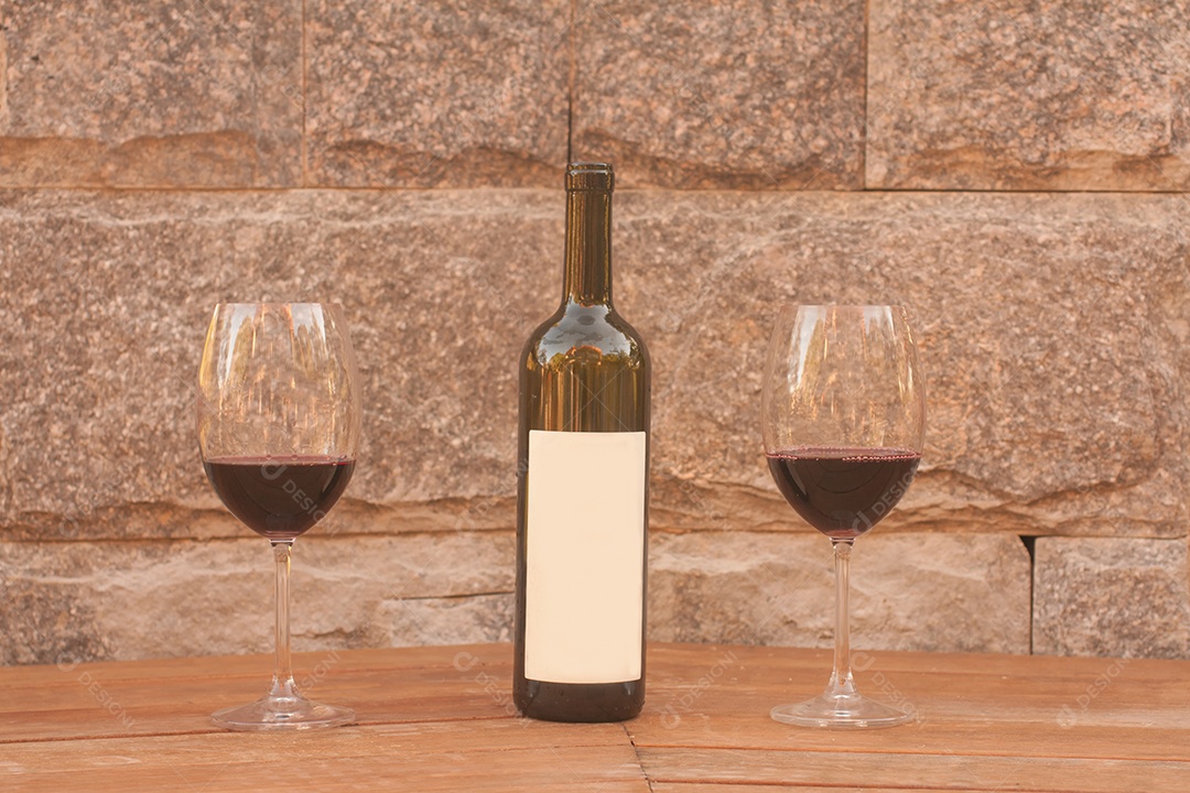 Garrafa de vinho no banco de madeira e fundo de pedra