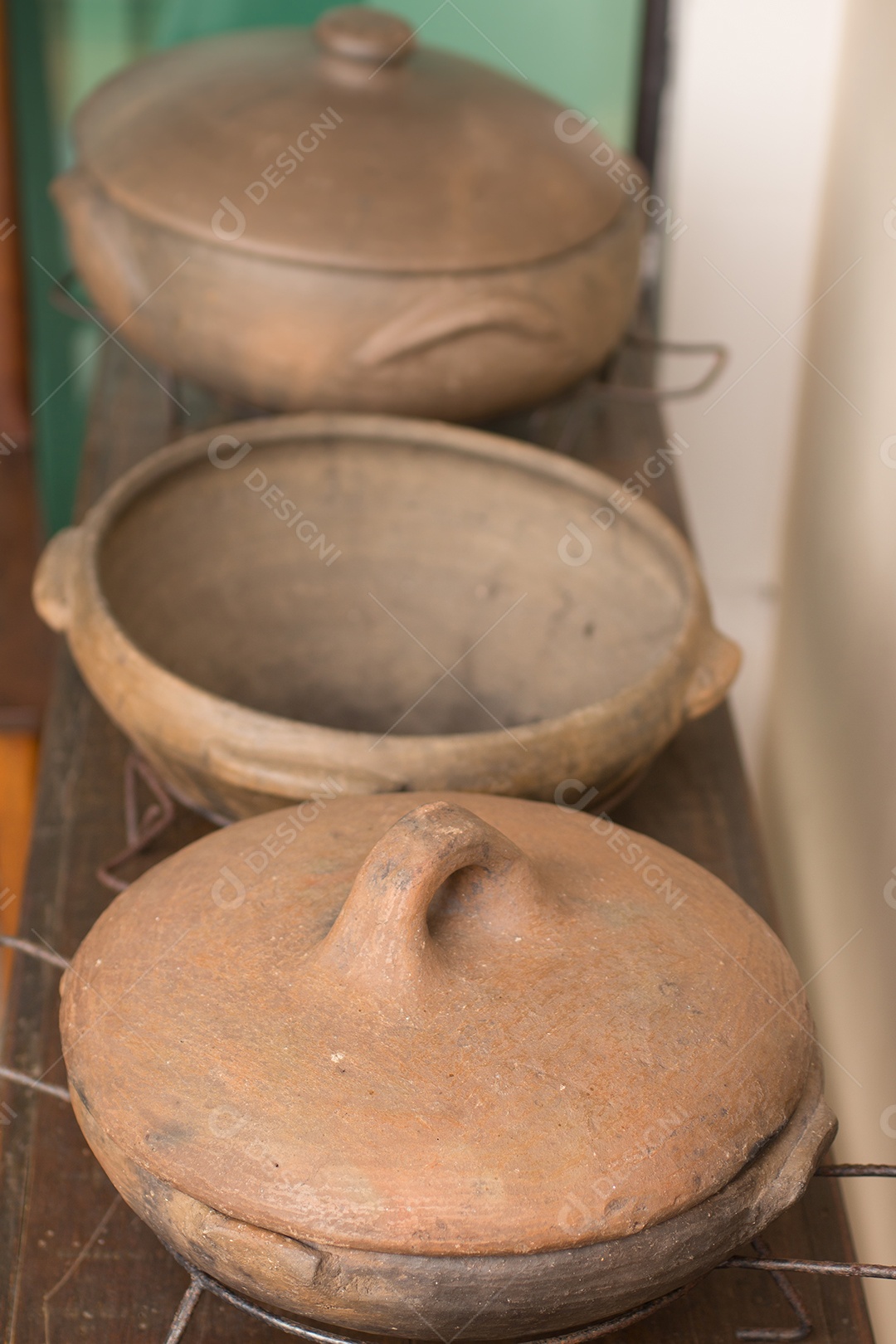 Panela de cerâmica rústica sobre uma mesa de madeira