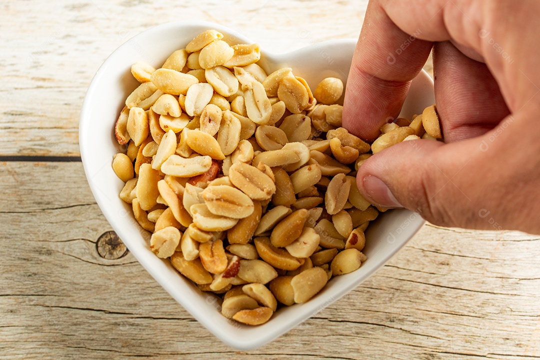 Recipiente em forma de coração com amendoim torrado sem casca e salgado