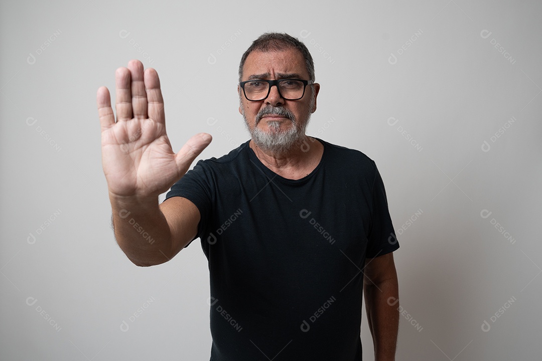 Homem maduro com barba e óculos, gesticulando em linguagem de sinais.