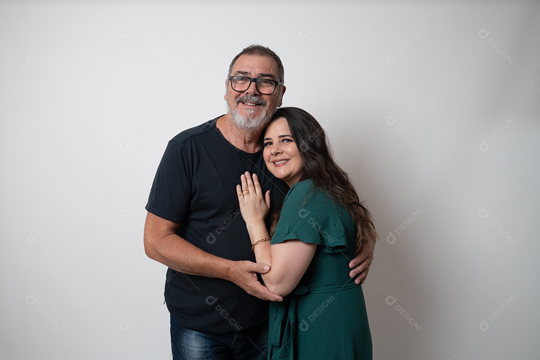 Pai e filha se abraçando, irradiando amor e felicidade, sorrindo felizes para a câmera.