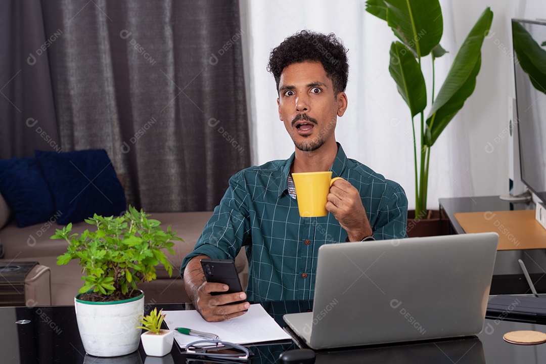 Jovem fazendo home office durante o dia na mesa com laptop