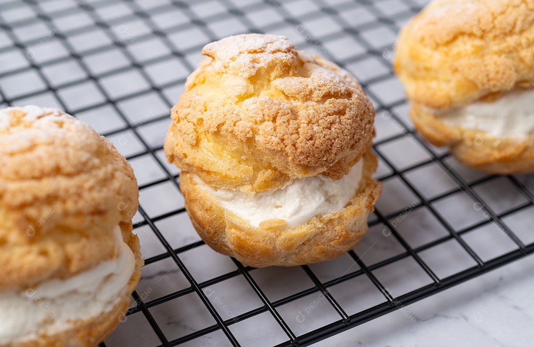 Creme de choux, bolo recheado com chantilly de baunilha sobre grade de metal.