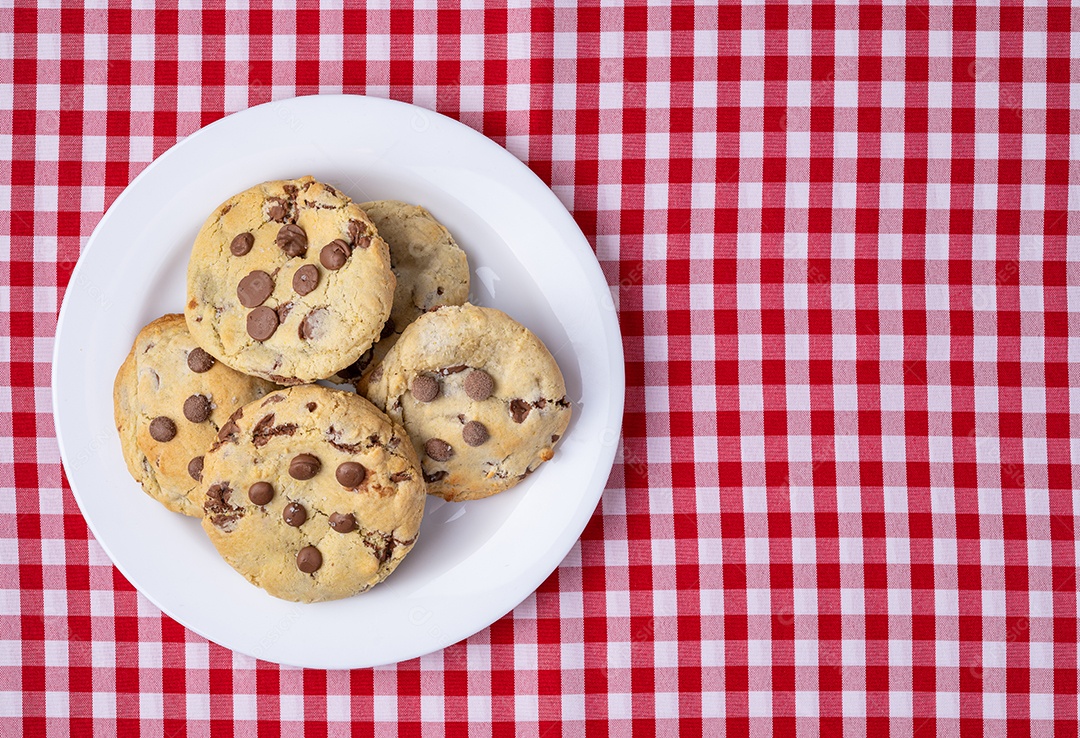 Biscoitos de chocolate em um prato sobre tecido xadrez com espaço de cópia.