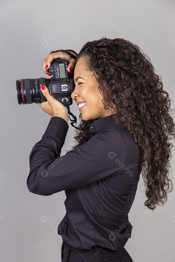 Linda mulher jovem sobre fundo isolado segurando câmera fotográfica