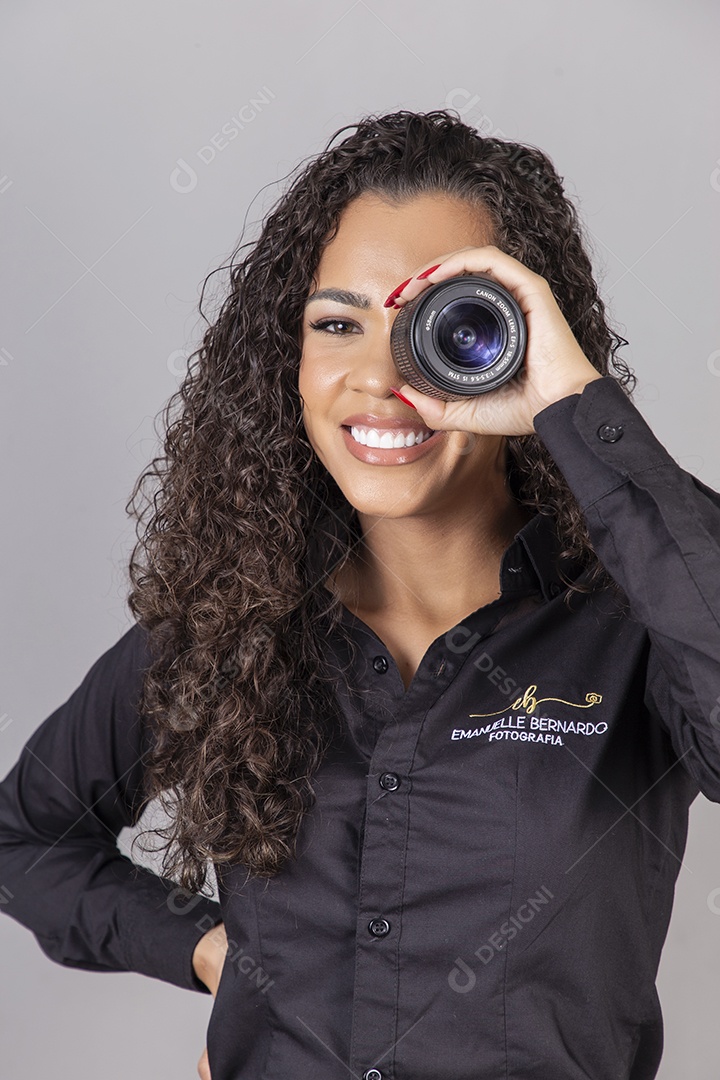 Linda mulher jovem sobre fundo isolado segurando câmera fotográfica