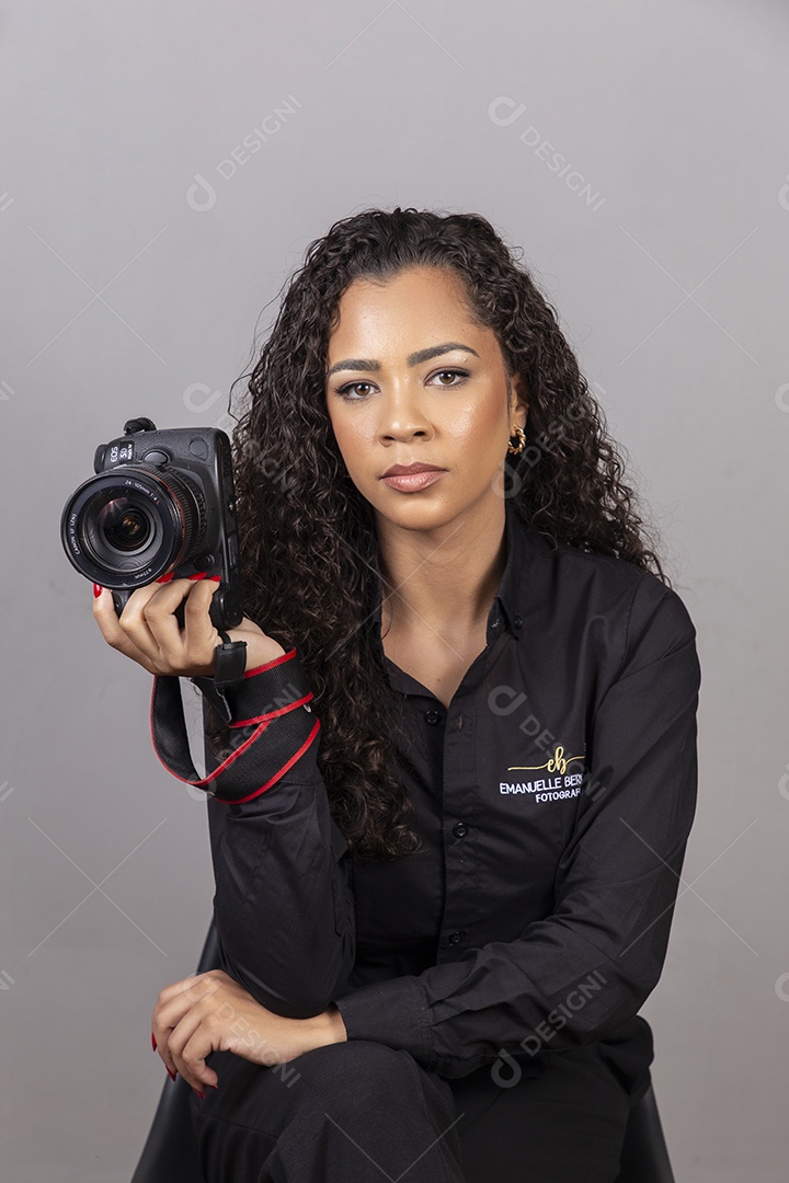 Linda mulher jovem sobre fundo isolado segurando camera fotográfica