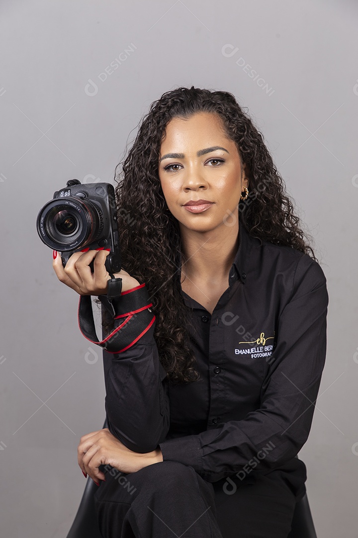 Linda mulher jovem sobre fundo isolado segurando câmera fotográfica