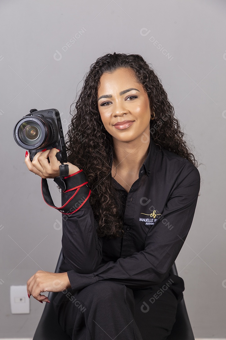 Linda mulher jovem sobre fundo isolado segurando câmera fotográfica
