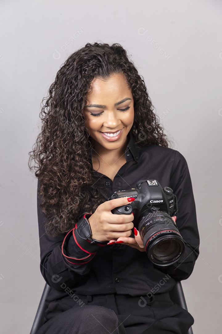 Linda mulher jovem sobre fundo isolado segurando câmera fotográfica