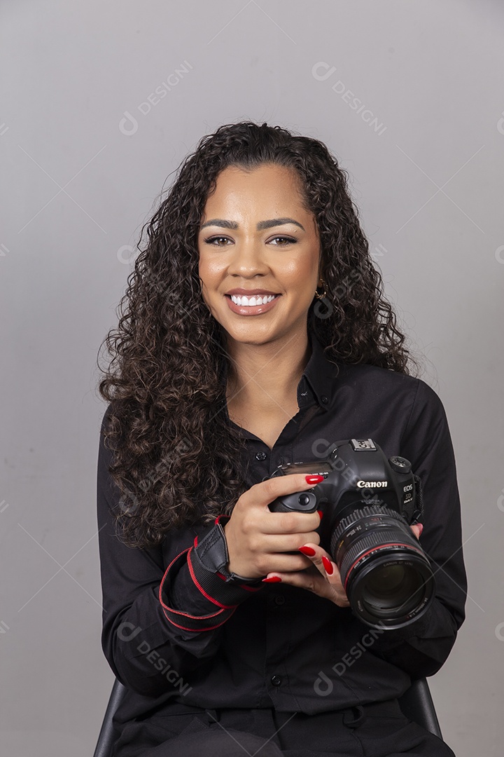 Linda mulher jovem sobre fundo isolado segurando câmera fotográfica