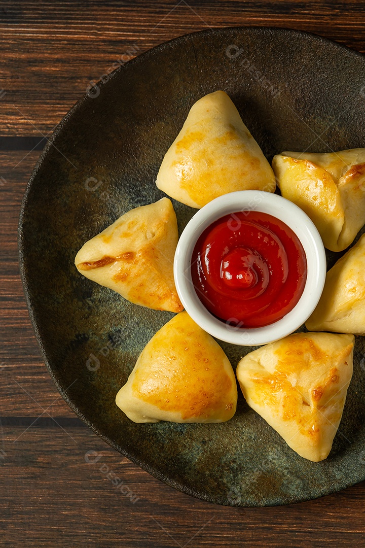 Esfiha assada ou assada, lanche de festa conhecido como salgadinho de festa em prato escuro