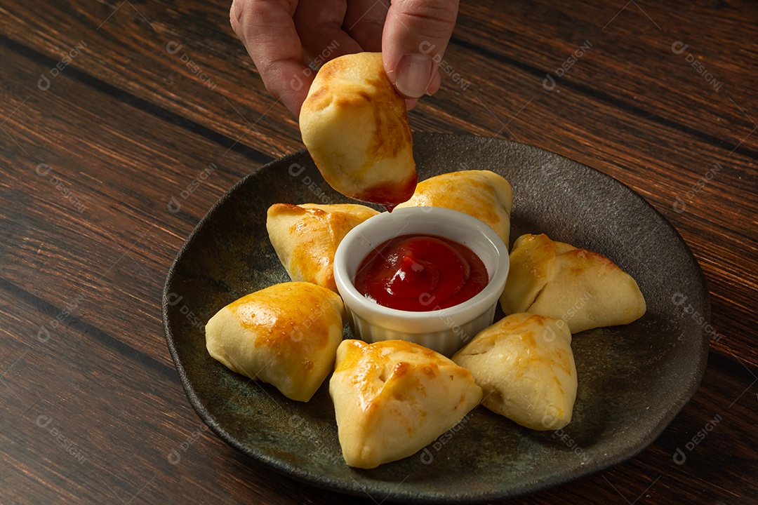 Esfiha assada ou assada, lanche de festa conhecido como salgadinho de festa em prato escuro