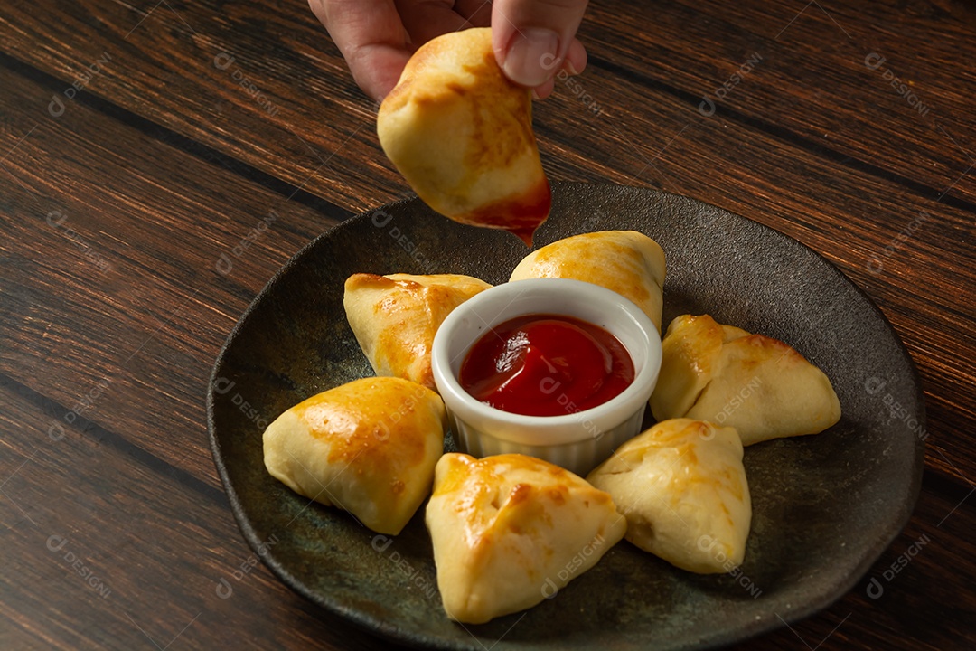 Esfiha assada ou assada, lanche de festa conhecido como salgadinho de festa em prato escuro