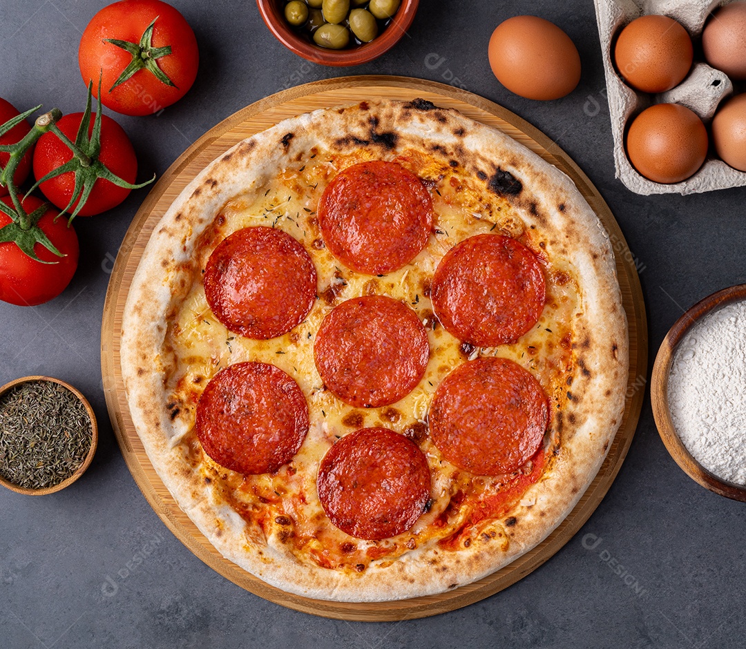 Pizza estilo salsicha calabresa sobre fundo de pedra com tomate, azeitonas e orégano.