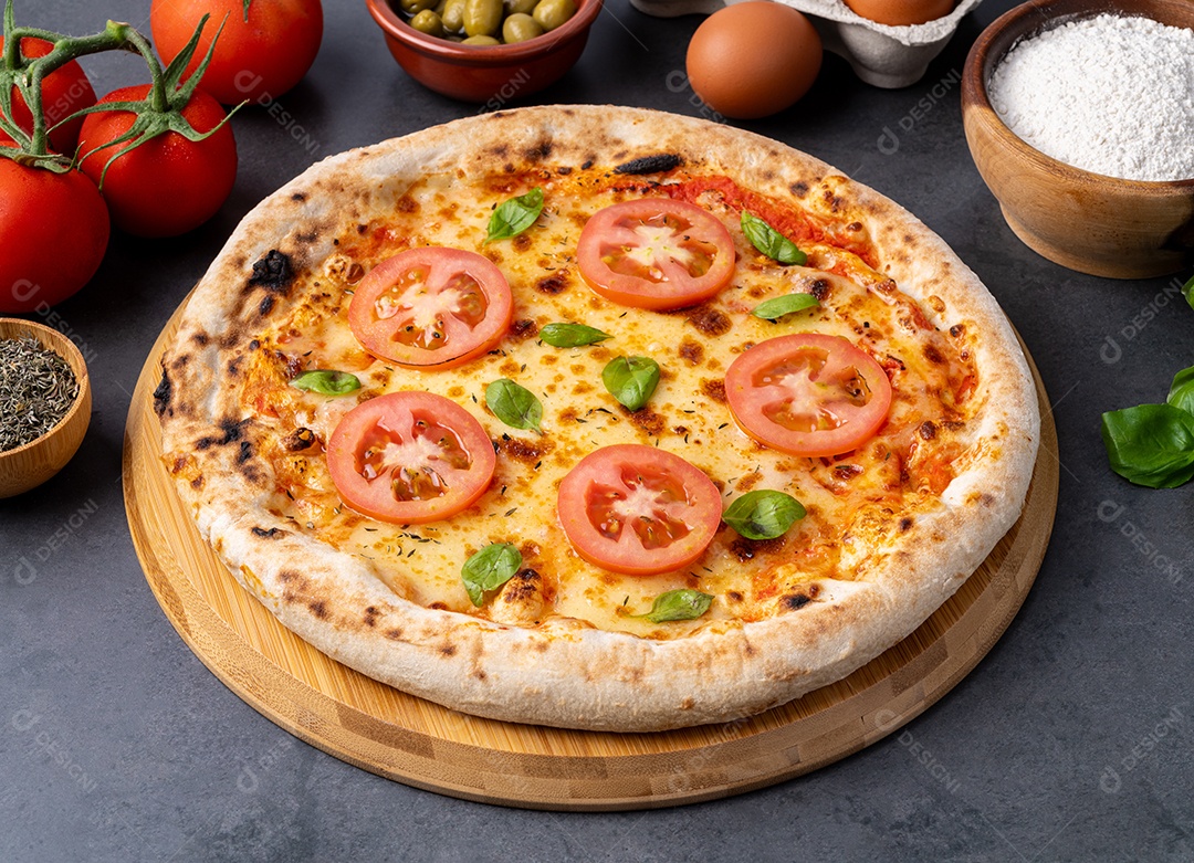 Pizza Margherita com tomate, azeite, ovos e farinha sobre a mesa de madeira.