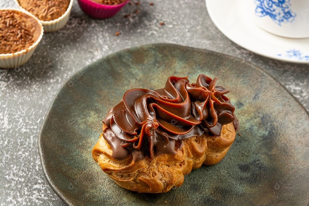 Bomba de chocolate ou éclair é uma padaria brasileira, sobremesa de comida doce, sobre mesa de mármore