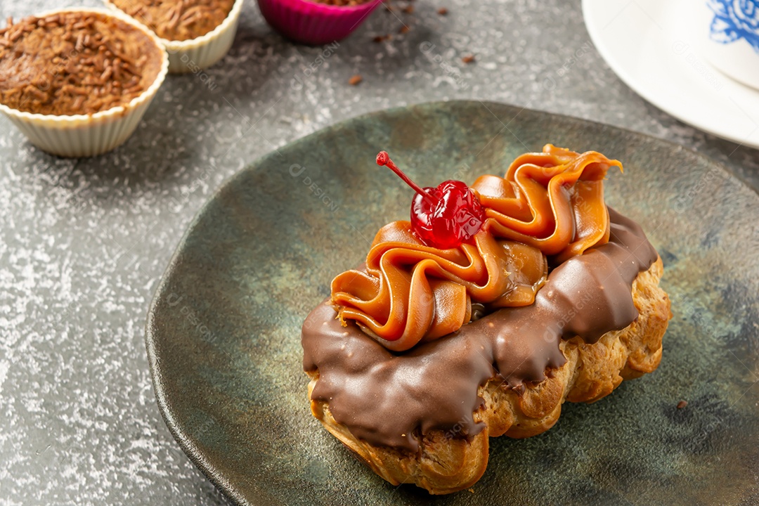 Bomba de chocolate ou éclair é uma padaria brasileira, sobremesa de comida doce, sobre mesa de mármore