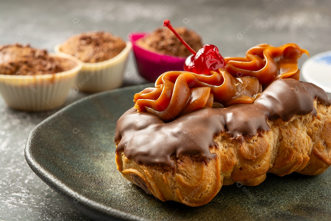 Bomba de chocolate ou éclair é uma padaria brasileira, sobremesa de comida doce, sobre mesa de mármore