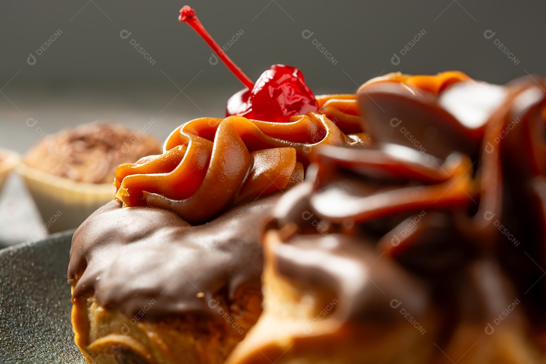 Bomba de chocolate ou éclair é uma padaria brasileira, sobremesa de comida doce, sobre mesa de mármore